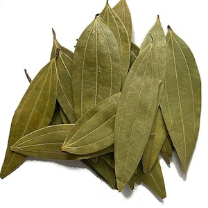 Pode incluir: Um monte de folhas de louro secas, exibindo uma cor verde suave com veias proeminentes. As folhas são alongadas e ovais, com uma textura ligeiramente áspera. A imagem é definida contra um fundo branco, destacando a cor e a forma natural das folhas.