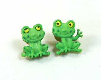 May include: A pair of green frog-shaped plastic earrings with yellow eyes.