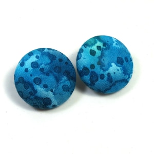May include: A pair of blue fabric earrings with a white and blue speckled pattern.