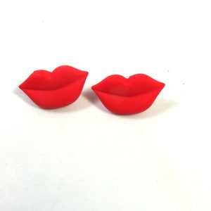 Könnte beinhalten: Ein Paar rote, glänzende Plastiklippen. Die Lippen sind in Form eines Schmollmunds geformt und sind ein lustiges und verspieltes Accessoire.