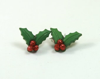 May include: A pair of green holly leaf earrings with red glitter berries.