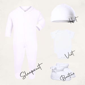 K&ouml;nnte beinhalten: Ein Set wei&szlig;er Babykleidung, darunter ein Schlafanzug, eine M&uuml;tze, ein Body und Babyschuhe. Der Schlafanzug hat lange &Auml;rmel und einen V-Ausschnitt. Die M&uuml;tze ist ein einfacher Beanie-Stil. Der Body ist ein kurz&auml;rmeliger Einteiler. Die Babyschuhe sind gestrickt.