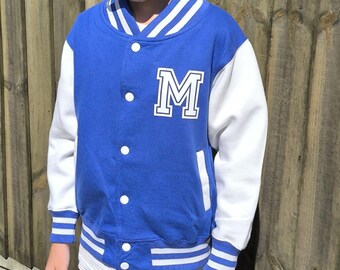 May include: A blue and white baseball jacket with a white letter "M" on the front. The jacket has white stripes on the collar, cuffs, and bottom.