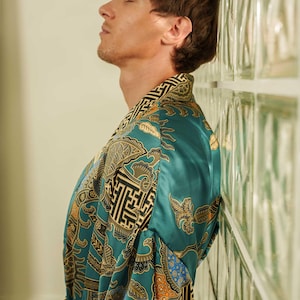 Close up of a man wearing teal satin kimono robe handmade in Bali. Long dressing gown is perfect gift for anniversaries, birthdays, christmas.