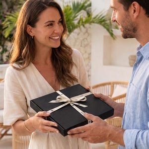 man gifting a woman TORÉ kimono robe in a black box tied with ribbon