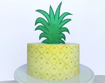 May include: A yellow pineapple cake with a green glitter pineapple topper.