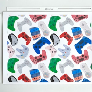 May include: A white background with a repeating pattern of colorful video game controllers. The controllers are in various shades of red, blue, green, and gray. The pattern is 8 inches by 10 inches.