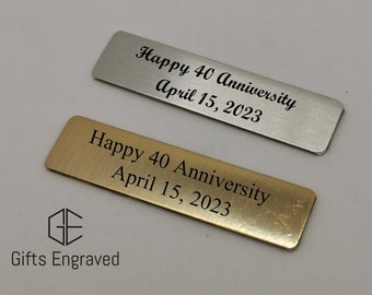 Könnte beinhalten: Zwei rechteckige Metallplaketten, eine silberne und eine goldene, mit der Inschrift "Happy 40 Anniversary April 15, 2023" in Schwarz. Das Logo "Gifts Engraved" befindet sich unten.