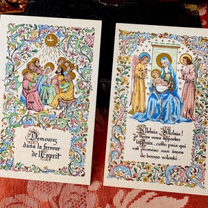 Puede incluir: Dos tarjetas religiosas vintage con ilustraciones coloridas y bordes florales ornamentados. Una tarjeta representa un grupo de figuras con una cruz y texto en francés. La otra muestra una escena religiosa con texto en francés.