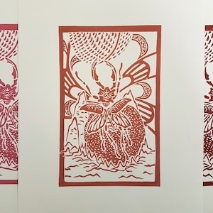 Può includere: Una stampa linoleografica rossa e bianca di uno scarabeo con le ali spiegate. Lo scarabeo è circondato da un motivo a spirale di foglie e fiori.