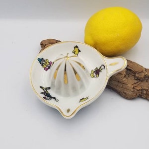 Francuska zabytkowa wyciskarka do cytryn Limoges Walt Disney, mała porcelanowa wyciskarka do cytryn. Postać z kreskówki i złote detale.