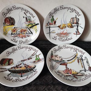 Peut inclure: Quatre assiettes ovales blanches avec des illustrations de scènes de cuisine en plein air. Chaque assiette porte l'inscription "Buffet Campagnard". Les assiettes représentent des grillades, des rôtis et des brochettes, avec du texte français en dessous.