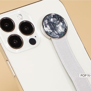 May include: White iPhone with a white Pop N Cases phone grip with a silver and iridescent round button.