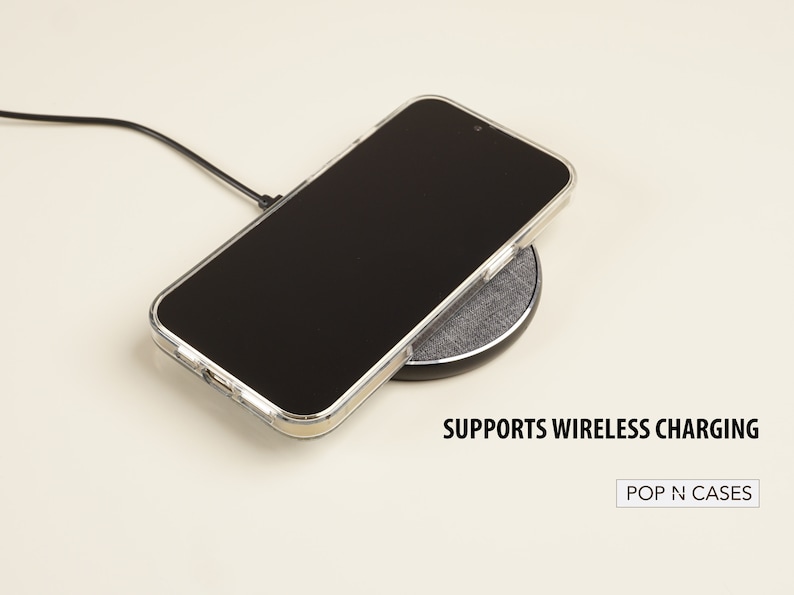 May include: A clear phone case on a wireless charging pad. The text "SUPPORTS WIRELESS CHARGING" is below the pad. The text "POP N CASES" is in a white rectangle below the text.
