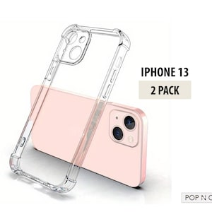 May include: Two clear iPhone 13 phone cases with raised edges for protection. The cases are shown on a pink phone. The text "IPHONE 13 2 PACK" is displayed above the phone cases. The text "POP N CASES" is displayed below the phone cases.