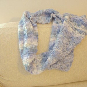 K&ouml;nnte beinhalten: Ein gestrickter Schal in Blau- und Wei&szlig;streifen mit einem strukturierten Muster.