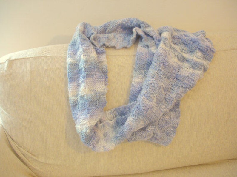 K&ouml;nnte beinhalten: Ein gestrickter Schal in Blau- und Wei&szlig;streifen mit einem strukturierten Muster.