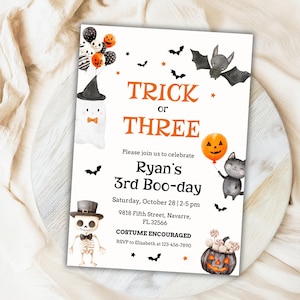 May include: Halloween party invitation with orange text reading "Trick or Three". The design includes illustrations of a ghost, bat, cat, and pumpkin. The invitation also states "Ryan's 3rd Boo-day" and event details.