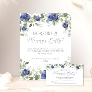 May include: A printable baby shower game card with a watercolor design of blueberries and greenery. The card says "How Big Is Mommy's Belly?" and includes instructions for guests to cut a piece of yarn to the length they think will fit around the mom-to-be's belly.