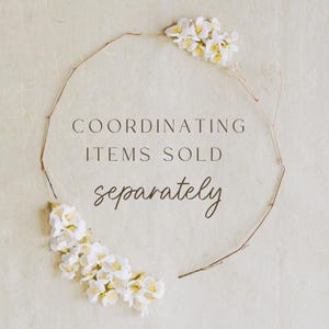 Op de afbeelding: Een witte achtergrond met een cirkel gemaakt van bruine takjes. De tekst "COORDINATING ITEMS SOLD separately" staat in het midden van de cirkel. Witte bloemen bevinden zich aan beide kanten van de cirkel.