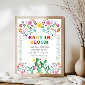May include: A colorful floral design with the text "BABY IN BLOOM" and the message "Plant these seeds and watch them bloom, just like the baby who will be here soon!"