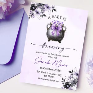 Könnte beinhalten: Eine rechteckige Babyparty-Einladungskarte mit einem schwarzen Kessel, einer violetten Schleife und violetten Blasen. Der Text lautet: A BABY IS brewing, please join us for a baby shower honoring Sarah Moore, 16 October, 2026, 201 Park Ave, Hershey, PA 17033, RSVP to Leana: 825-658-3214. Violette und schwarze Blumenmotive verzieren die Ecken der Karte.