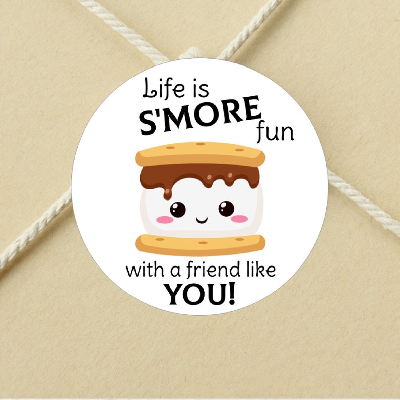 May include: A white circle sticker with a cartoon s'more. The s'more has a smiling face and is labeled "Life is S'MORE fun with a friend like YOU!"