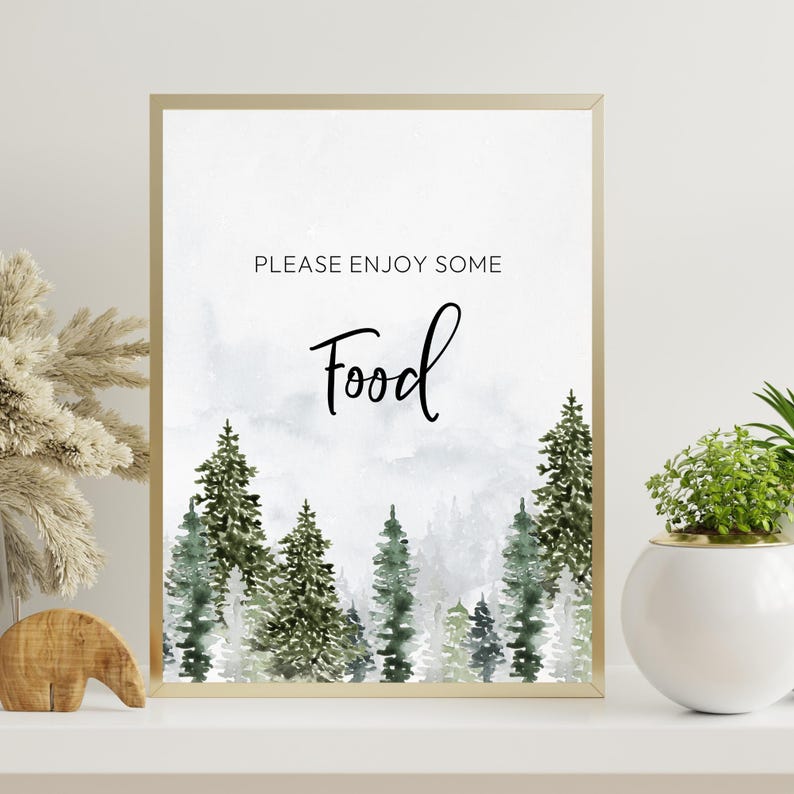 May include: A rectangular print in a gold frame featuring a watercolour forest of green pine trees against a light grey background. The text "PLEASE ENJOY SOME" is printed in black sans-serif font above the word "Food" in a black script font.