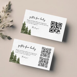 May include: Two white cards with the text "gifts for baby" in a handwritten style. The cards include text about a baby registry and a QR code. The cards are decorated with a small illustration of evergreen trees.