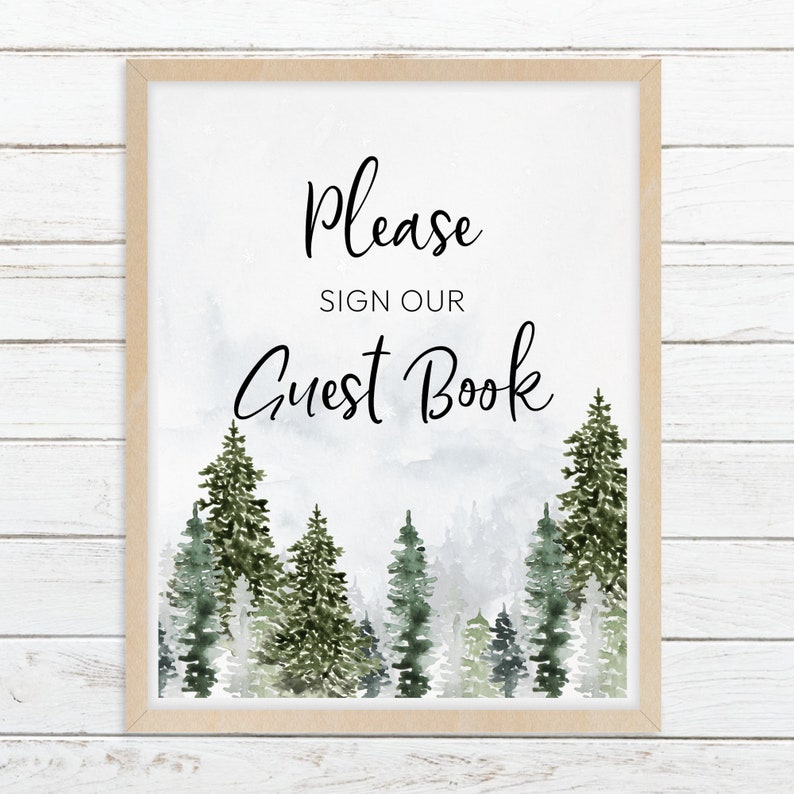May include: A rectangular sign in a light wood frame featuring the black text Please SIGN OUR Guest Book centred above a watercolour illustration of a dense forest with various shades of green pine trees against a misty white background.