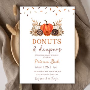May include: A white rectangular invitation card featuring a watercolour illustration of pumpkins, dried grasses, and doughnuts at the top. The text reads DONUTS & diapers, JOIN US FOR A BABY SPRINKLE HONORING Patricia Beck, October 26, 2 pm, 340 SUNSHINE AVE. NEW YORK, MN, RSVP MANDY (873) 847-1345, Registered at Target.