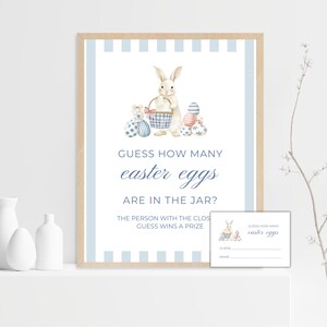 Puede incluir: Un letrero de juego de Pascua enmarcado con una ilustración de acuarela de un conejito sosteniendo una canasta de huevos. El texto dice "¿Adivina cuántos huevos de Pascua hay en el frasco?" e incluye una tarjeta de juego a juego.