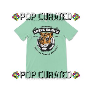 May include: A light green t-shirt with a tiger graphic and the text "Indian Cuisine Shere Kahn's Fresh Daily Tropical Jungle Delights".