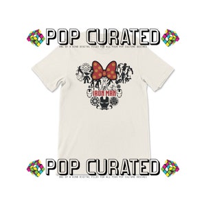 K&ouml;nnte beinhalten: Ein wei&szlig;es T-Shirt mit einer rot-wei&szlig;en Schleife und einer schwarz-wei&szlig;en Grafik von Iron Man und anderen Marvel-Charakteren. Der Text "Iron Man" ist unter der Grafik gedruckt. Der Text "POP CURATED" ist oben und unten im Bild gedruckt.