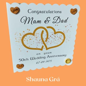 Tarjeta de aniversario de bodas de oro personalizada para mamá y papá con diseño de corazones dorados y adornos.