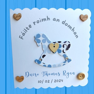 Biglietto per bebè personalizzato per un bambino con il disegno del cavallo a dondolo in lingua irlandese