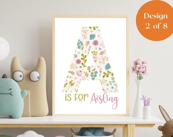 Puede incluir: Un estampado floral enmarcado con la letra "A" llena de flores rosas, azules y verdes. El texto "is for Aisling" está debajo de la letra. El diseño está etiquetado como "Design 2 of 8" en un círculo naranja.