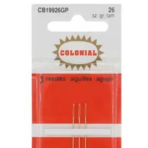 May include: A pack of three gold-plated tapestry needles, size 26, by Colonial. The needles are arranged vertically on a red card within a clear plastic sleeve. The packaging features the text CB19926GP, 26, Colonial, and Gold Plated Tapestry Petites.