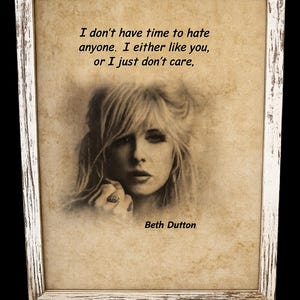 May include: A framed print featuring a sepia-toned portrait of a blonde individual with the text: I don't have time to hate anyone. I either like you, or I just don't care, and the name Beth Dutton. The frame is white with a distressed, weathered finish.