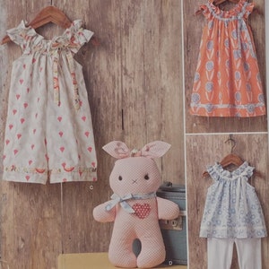 May include: Simplicity sewing pattern number 8347 for a girl's dress and a bunny toy. The pattern includes four different styles: a dress with a ruffled neckline, a dress with a floral print, a dress with a ruffled neckline and leggings, and a bunny toy with a heart on its chest. The pattern is designed for sizes 1/2-4.