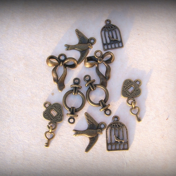 8 breloques décorées couleur bronze antique, trèfle 4 feuilles ,nœud, hirondelle, cœur