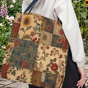 May include: A patchwork tote bag with a floral and sunflower design. The bag features a variety of fabric patterns in shades of red, blue, and beige. The bag has a navy blue strap and is carried over the shoulder.