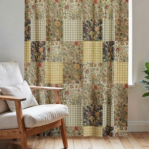 May include: Patchwork curtain with a mix of floral, gingham, and solid square patterns in shades of beige, green, and navy blue. The curtain hangs from a black rod in front of a window. A wooden chair with a cream cushion sits to the left.