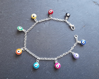 May include: A silver chain bracelet with multiple colorful evil eye charms. The charms are in shades of red, yellow, green, orange, blue, and purple.