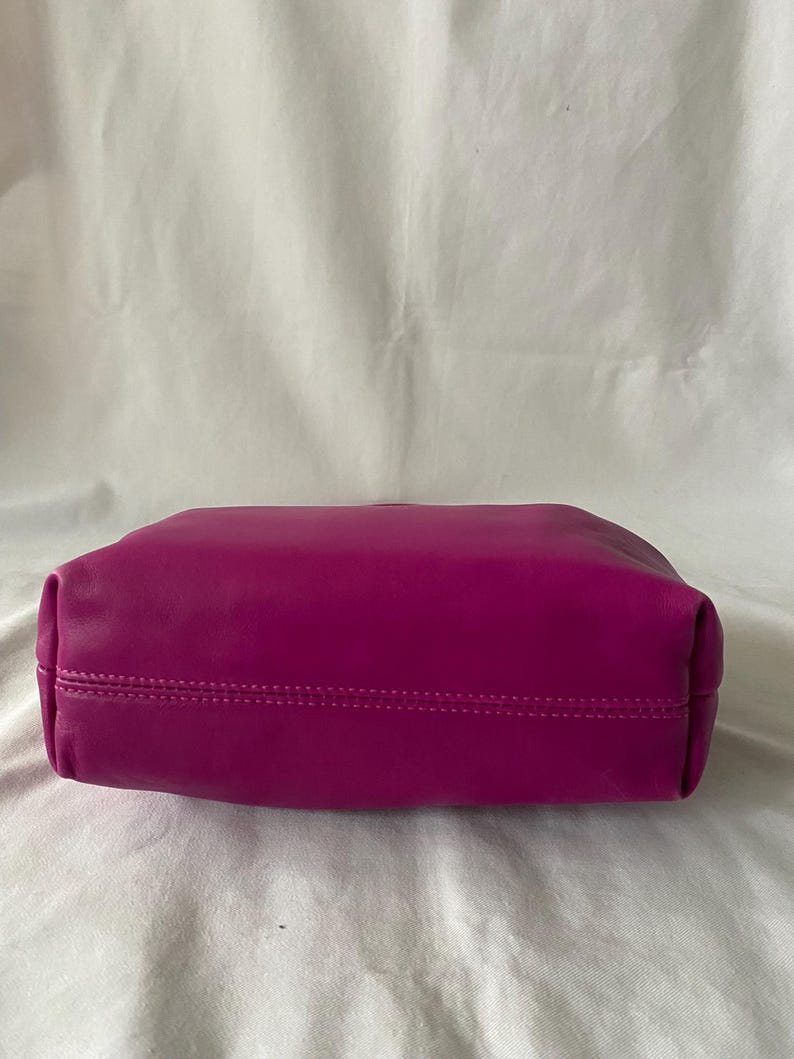 May include: A vibrant magenta leather tote bag with a stitched seam around the top edge.