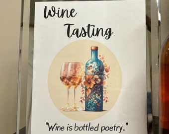 May include: A sign with the text "Wine Tasting" and a picture of a wine glass and bottle with flowers. The quote "Wine is bottled poetry." by Robert Louis Stevenson is below the image.