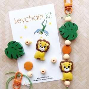 May include: A keychain kit with a lion, monstera leaf, and beads. The kit includes a green string, a silver clasp, and a card that says "keychain kit".