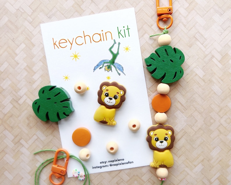 May include: A keychain kit with a lion, monstera leaf, and beads. The kit includes a green string, a silver clasp, and a card that says "keychain kit".