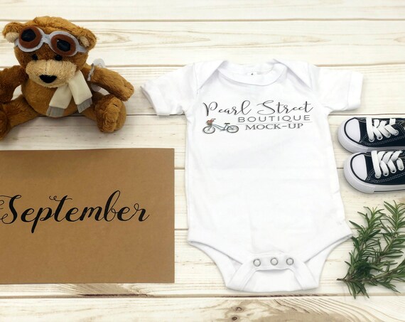 White Onesie Mockup On Wood With Toy Stuffed Bear White Onesie Mockup On Wood With Toy Stuffed Bear