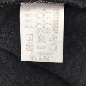 May include: A white tag with black text and symbols. The tag provides information about the fabric content and care instructions for a garment. The text includes percentages for cotton, polyester, and polyurethane. The tag also includes symbols for washing, drying, ironing, and bleaching. The text at the bottom of the tag reads "Gunze Co., Ltd. 0120-167874 JP-0 Made in China."